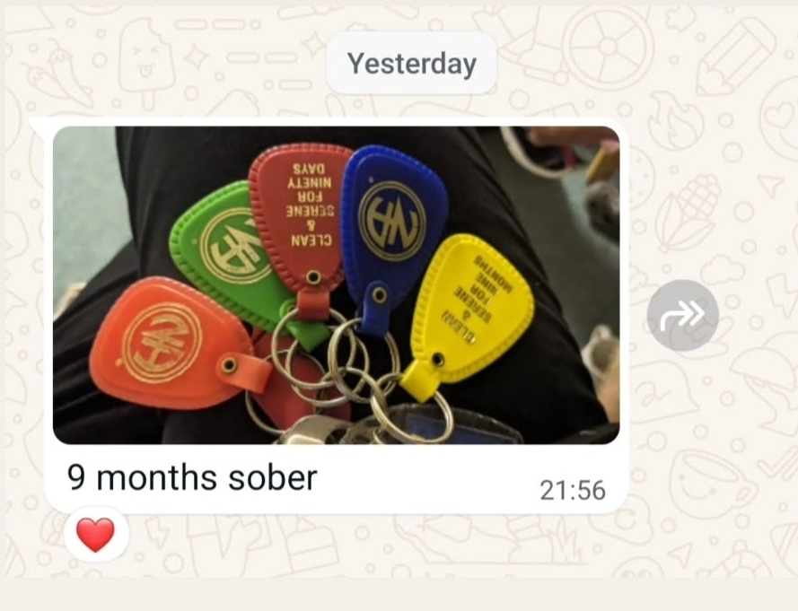 WhatsApp photo from a client of a bunch of coloured recovery key tags, captioned “9 months sober”, with a heart reaction.